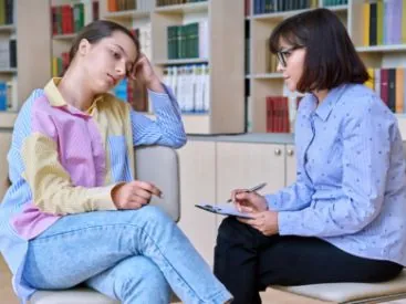 School counselor taking notes during a one-on-one behavioral support session with a student